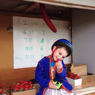 a young boy in a blue and orange outfit