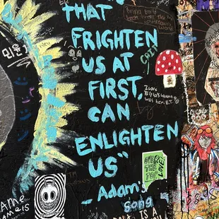 a wall covered in graffiti and stickers