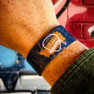 a person&apos;s wrist with a wristband with a logo on it