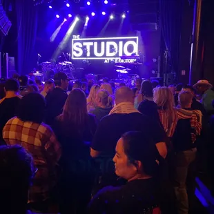 a crowd of people standing in front of a stage