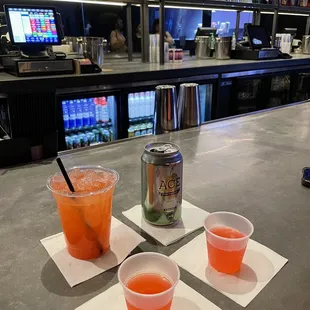 three cups of juice and a can of soda