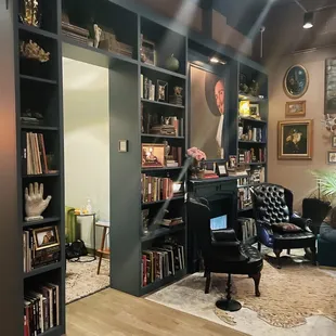 a man sitting in a chair in front of a bookshelf