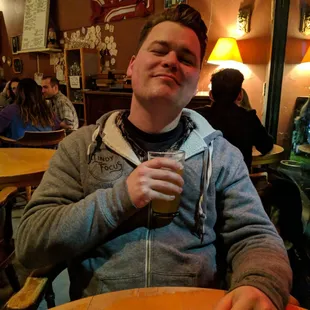 a man sitting at a table with a glass of beer