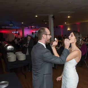 a bride and groom feeding each other a piece of cake