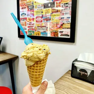 a person holding a cone of ice cream