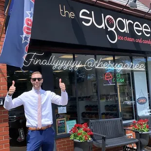 a man holding a flag outside of a store