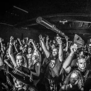 a crowd of people raising their hands in the air