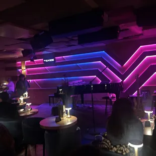 people sitting at tables in a dimly lit restaurant