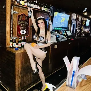 a woman in a bikini sitting at a bar