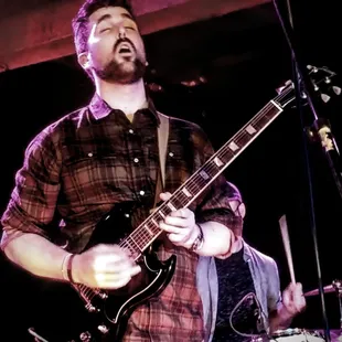 a man playing a guitar on stage