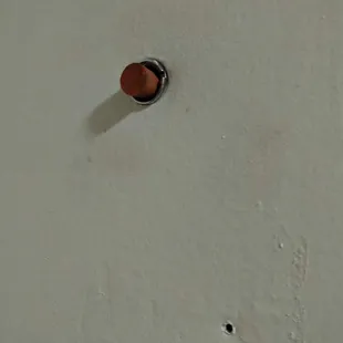 Close up of dirty, disposable ear plug to cover peep hole.