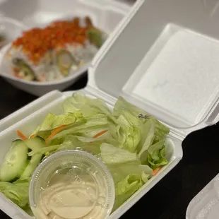 a container of salad and a container of dressing