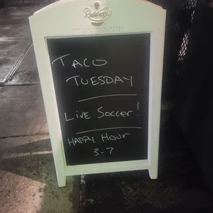 a chalkboard with the words taco tuesday live soccer happy hour