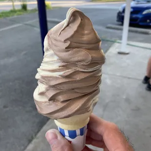 a hand holding a cone of ice cream