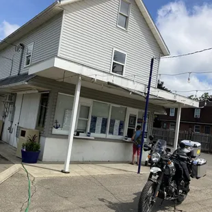 two motorcycles parked in front of a white building
