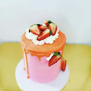 a pink cake with strawberries on top