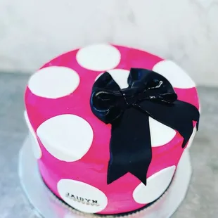 a pink and white polka dot cake