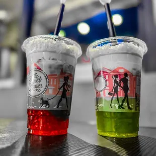 two plastic cups with drinks in them
