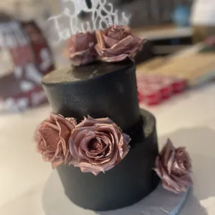a three tiered cake with pink roses