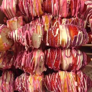a box of strawberries covered in pink and white icing