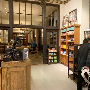 a man in a black jacket standing in front of the cash register