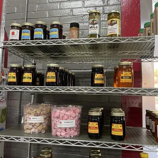 a shelf full of honeys, jams and jellys