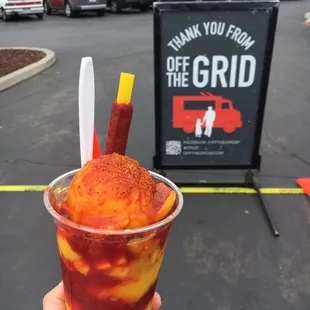 a hand holding a cup of ice cream