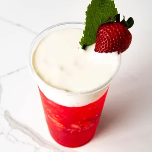 a cup of yogurt with a strawberry on top