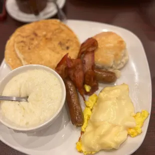 Big eaters breakfast ; two eggs, sausage, bacon, grits, two stacked pancakes with a biscuit!