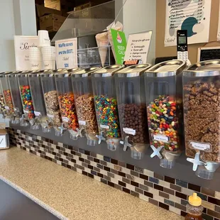 a row of candy dispensers on a counter