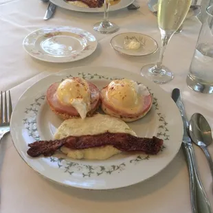 Eggs Benedict with peppered bacon and cheesy grits! It was delicious!!