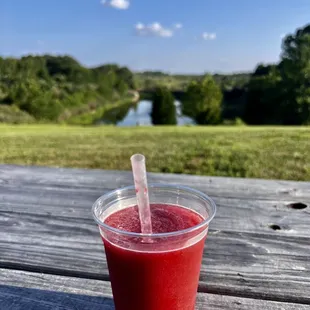a drink in a plastic cup on a picnic table