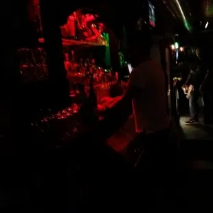 a man standing at a bar in the dark