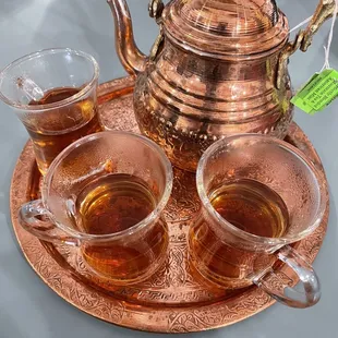 three cups of tea and a copper teapot