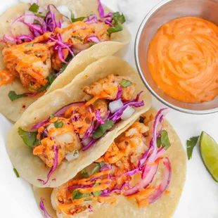 Shrimp Tacos garnished with red cabbage, cilantro, onions and our delicious Chipotle sauce