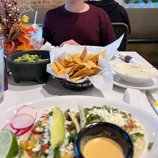Mahi tacos (add avocado and queso fresco), chicken taco (add queso fresco), bean dip, chips and large portion of guacamole.