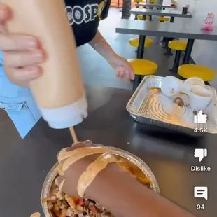 Pouring sauce onto a customers hand