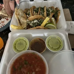 A variety of tacos and steak quesadilla with sauces and chips!