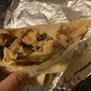 a hand holding a taco