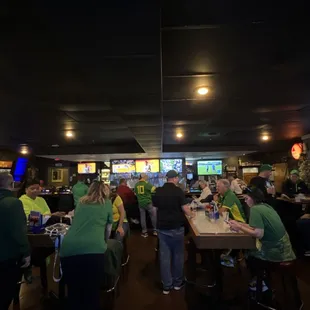 a large group of people in green shirts