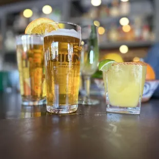 two glasses of beer and a margarita