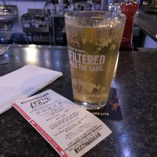 a glass of beer and a ticket