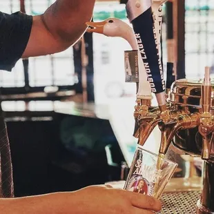 a man pouring a beer at a bar