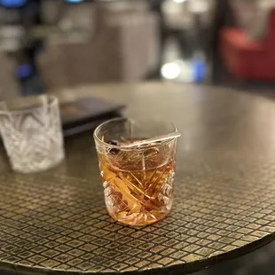 a glass of whiskey on a table