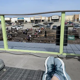 a person's feet on a bench overlooking a train yard