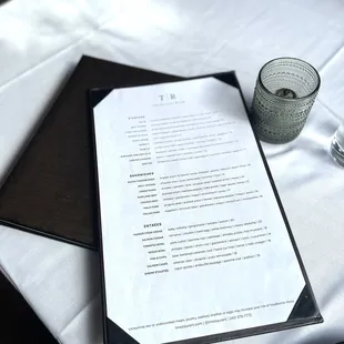 a menu and a glass of water