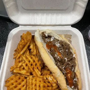 cheesesteak with hot sauce and waffle fries