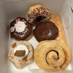 Biscoff cookie, peppermint bark, chocolate iced with sprinkles, Boston cream, Tatonut, and a glazed Katrina piece