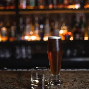 two glasses of beer on a bar counter