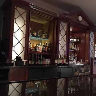 a bar with wine glasses on the counter
